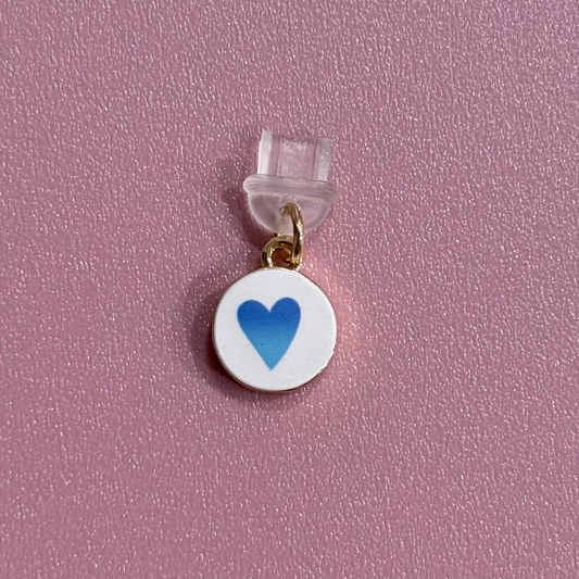 Small charm with a blue heart on a pink background