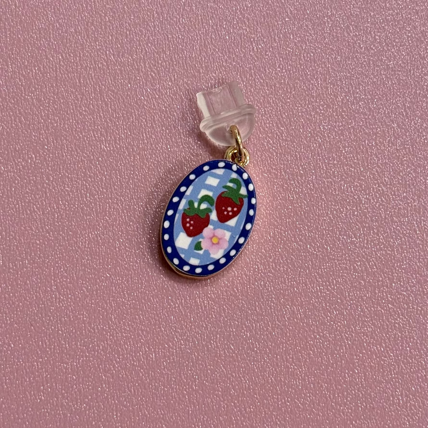 Small round pendant with strawberry design on a pink background
