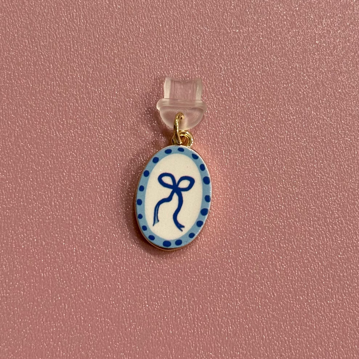 Small oval pendant with blue design on a pink background