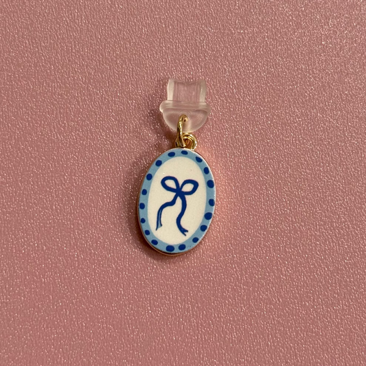 Small oval pendant with blue design on a pink background