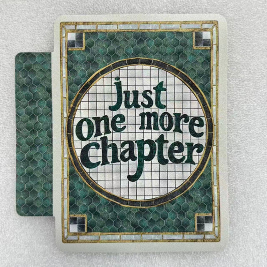 Book with 'Just one more chapter' text on a textured surface